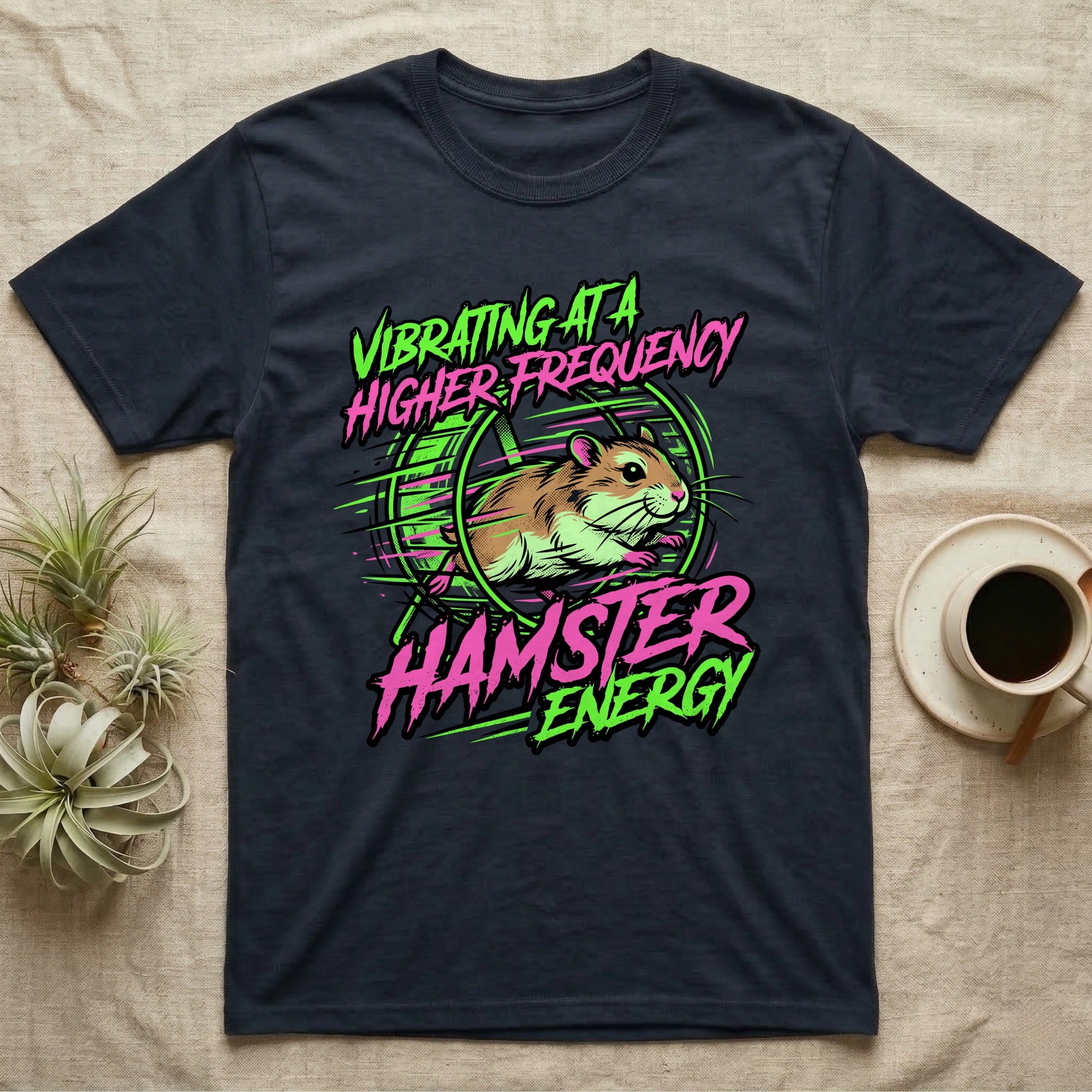 Dark t-shirt with neon green and pink graphic of a hamster running in a wheel with text "VIBRATING AT A HIGHER ENERGY HAMSTER ENERGY".