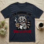 T-shirt with raccoon holding "Chaos Fuel" mug, text "I'M RUNNING ON CHAOS & CAFFEINE".
