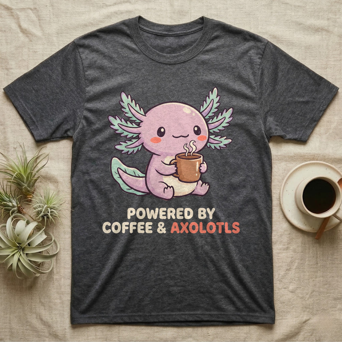 Coffee And Axolotls T-Shirt in Dark Heather — Kawaii chibi illustration of an axolotl holding a coffee cup with soft text reading Powered By Coffee And Axolotls.