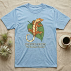 Light blue t-shirt featuring a crested gecko on a green leaf.