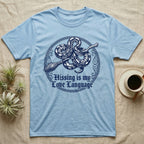 Ball Python Hissing Love Language T-Shirt in Light Blue — Navy engraving of a ball python coiled around a broomstick in a knotwork ring, "Hissing Is My Love Language."