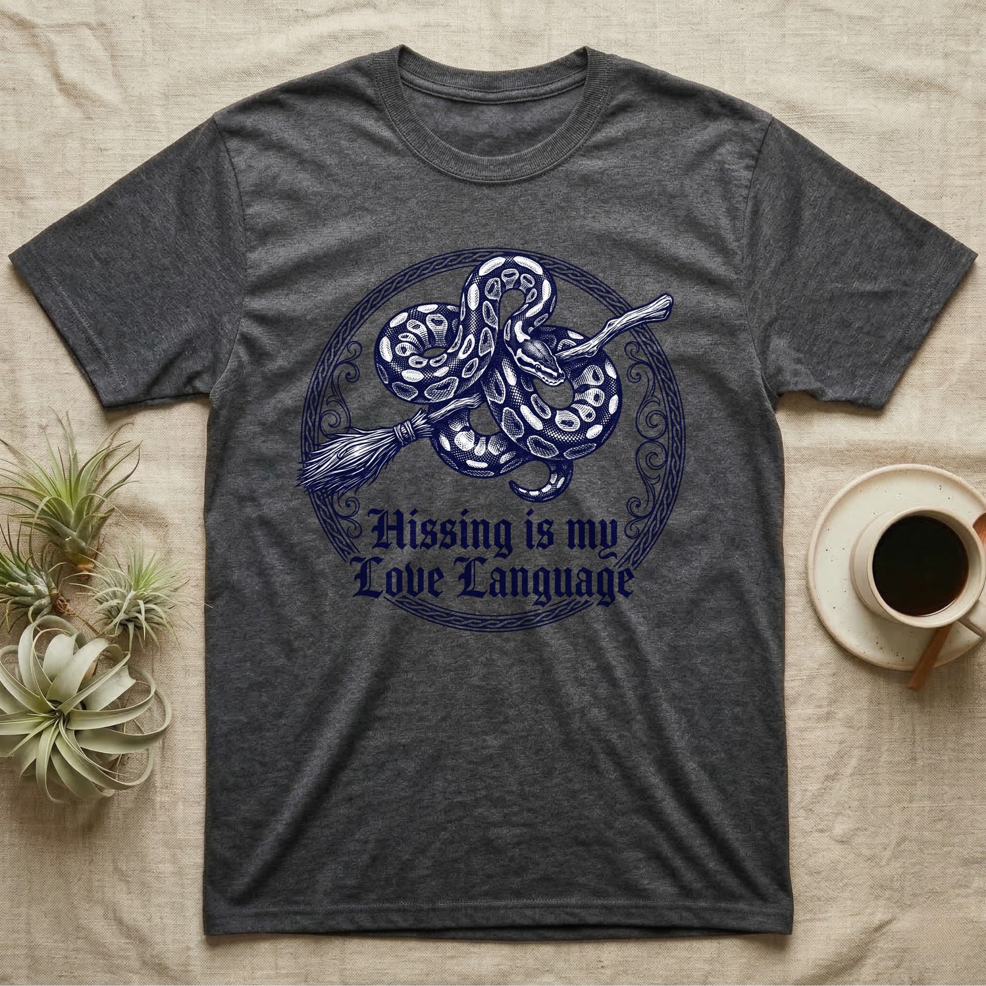 Ball Python Hissing Love Language T-Shirt in Dark Heather — Navy engraving of a ball python coiled around a broomstick in a knotwork ring, "Hissing Is My Love Language."