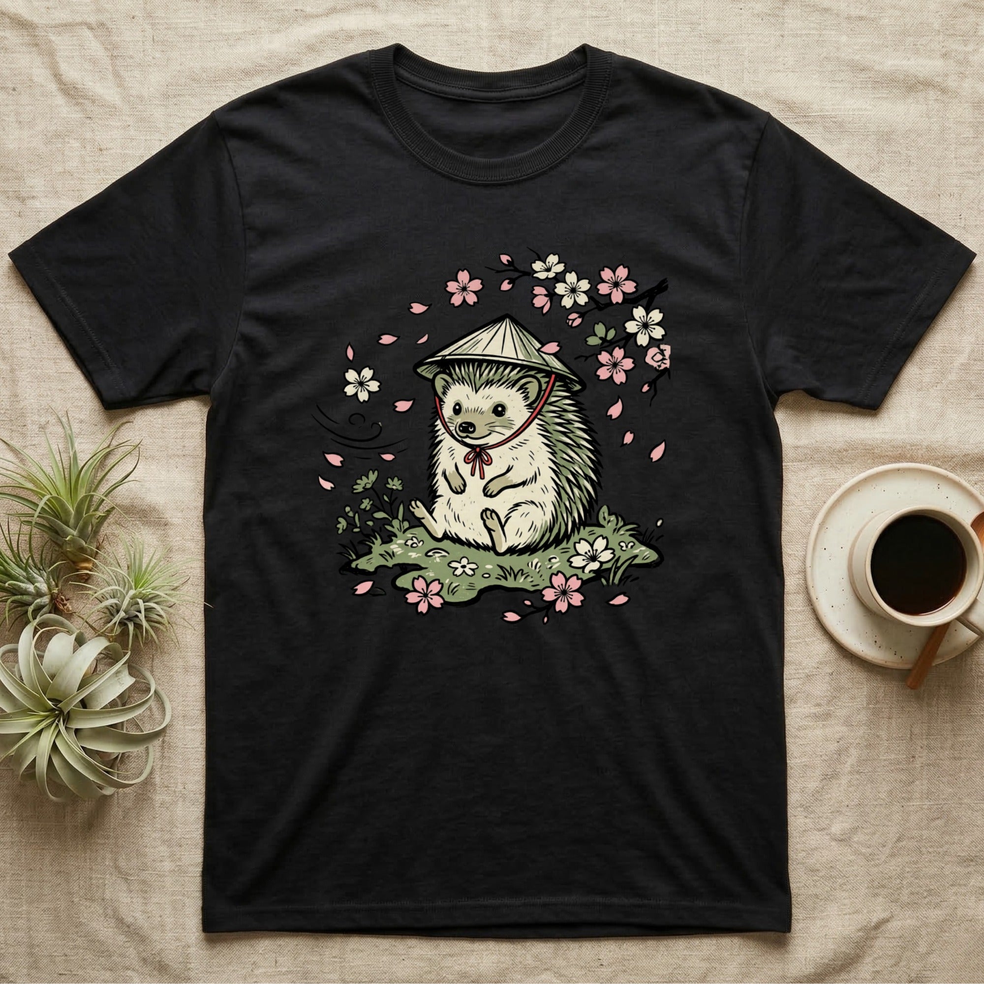 Black t-shirt with a hedgehog wearing a straw hat among cherry blossoms.