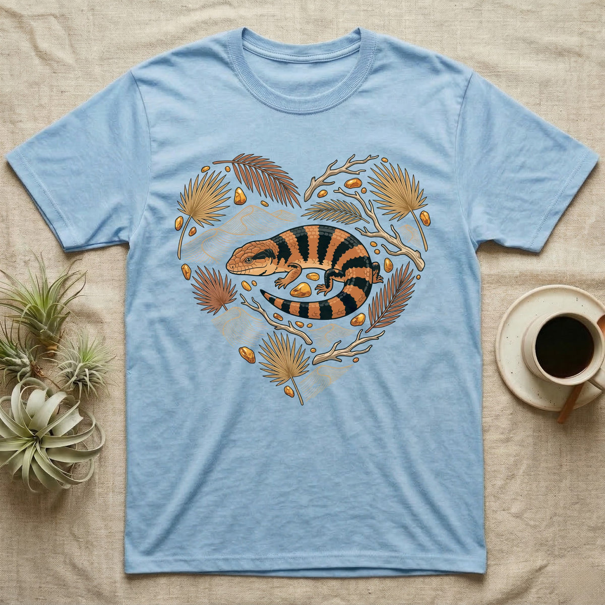 Light blue t-shirt with orange and black striped lizard in heart-shaped floral design.