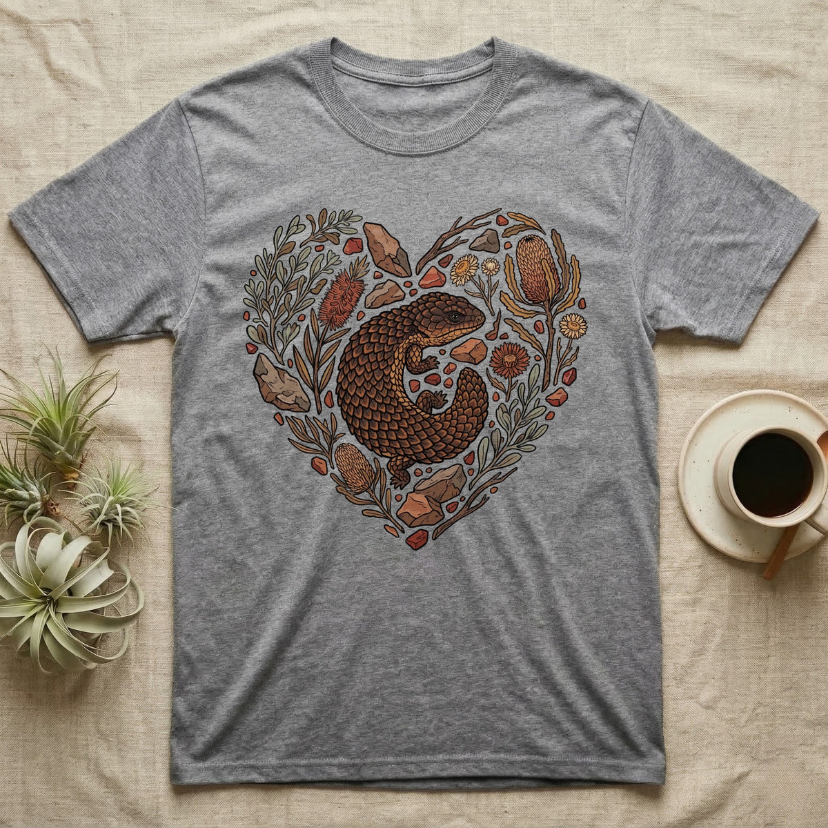 Grey t-shirt with a heart-shaped floral design featuring an armadillo lizard.