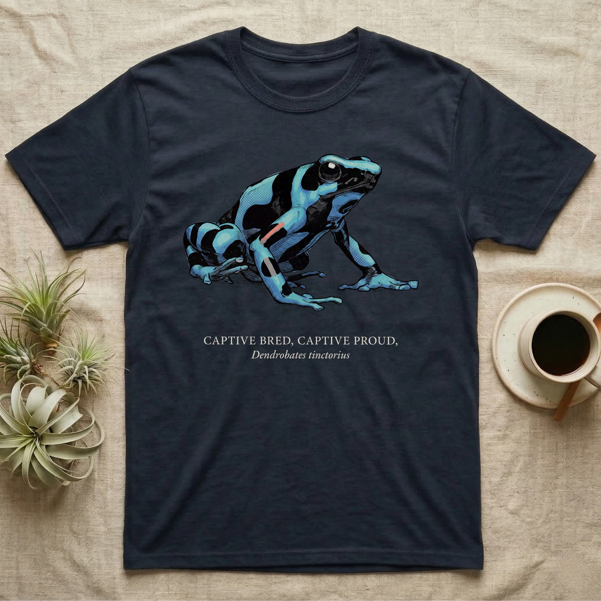 Captive Bred Frog T-Shirt in Navy — Naturalist-plate illustration of a healthy dyeing dart frog above a serif creed reading Captive Bred Captive Proud.