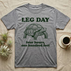 Sulcata Tortoise Leg Day T-Shirt in Sport Grey — Engraved sulcata tortoise in deep green ink beneath the words LEG DAY, with four hours, one hundred feet below.