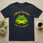 Dark t-shirt with a cartoon frog and the text "I Must Scream For Crickets".