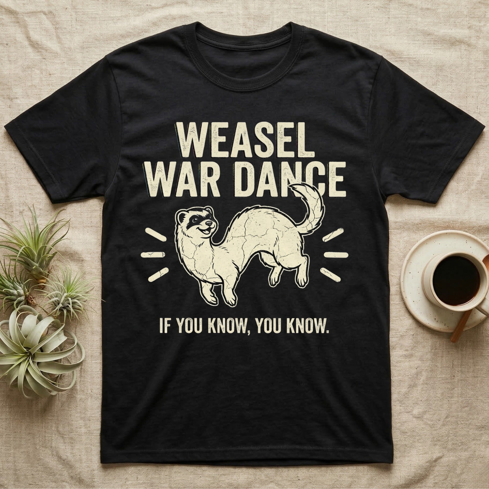 Weasel War Dance Ferret Tee in Black — Grunge-distressed ferret mid-war-dance in S-curve bounce with stacked type "Weasel War Dance / If You Know."