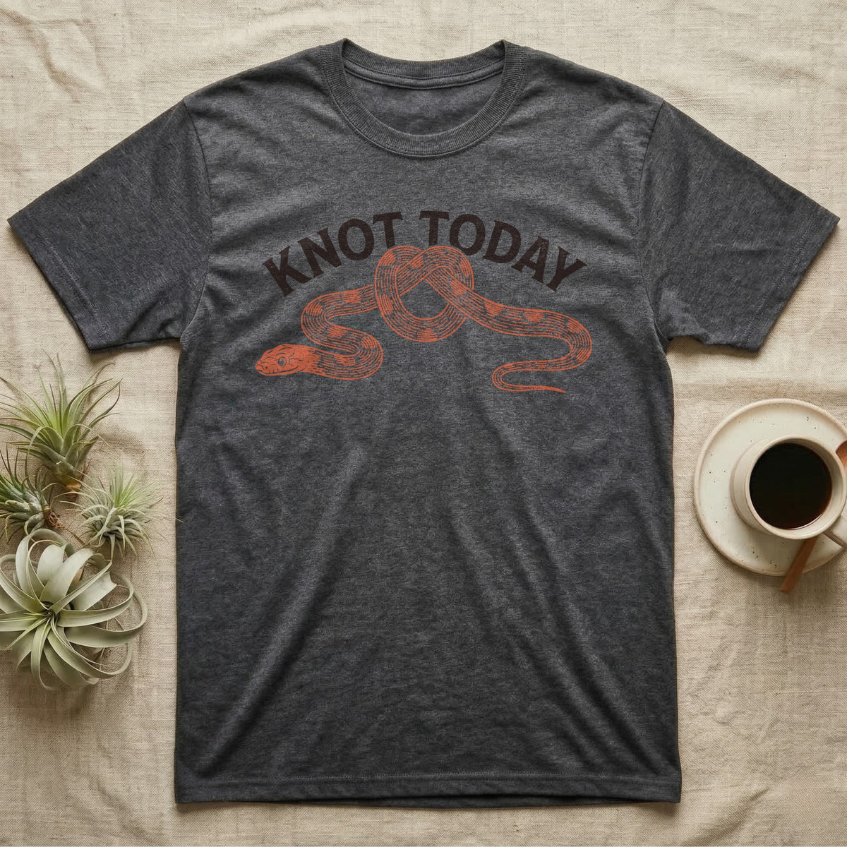 Corn Snake Knot Today T-Shirt in Dark Heather — Worn-stamp corn snake stretched into a half-tied bow beneath a fat arched "KNOT TODAY" headline.