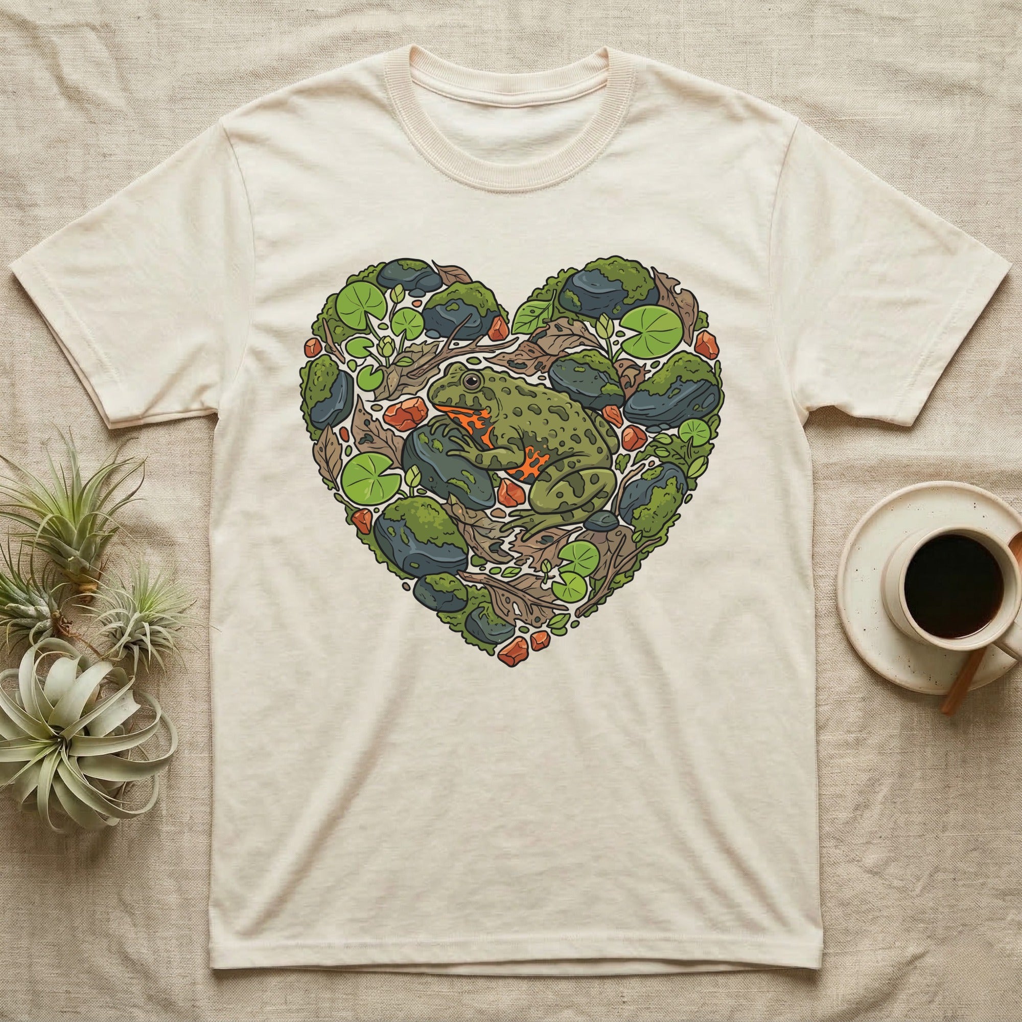 Cream t-shirt with a heart-shaped design of a frog and natural elements.