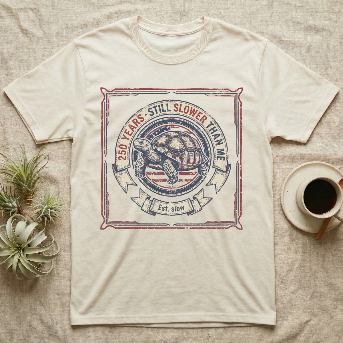Slower Than Me Tortoise T-Shirt in Natural — Vintage-Americana roundel illustration of a tortoise with a banner reading "250 Years, Still Slower Than Me."