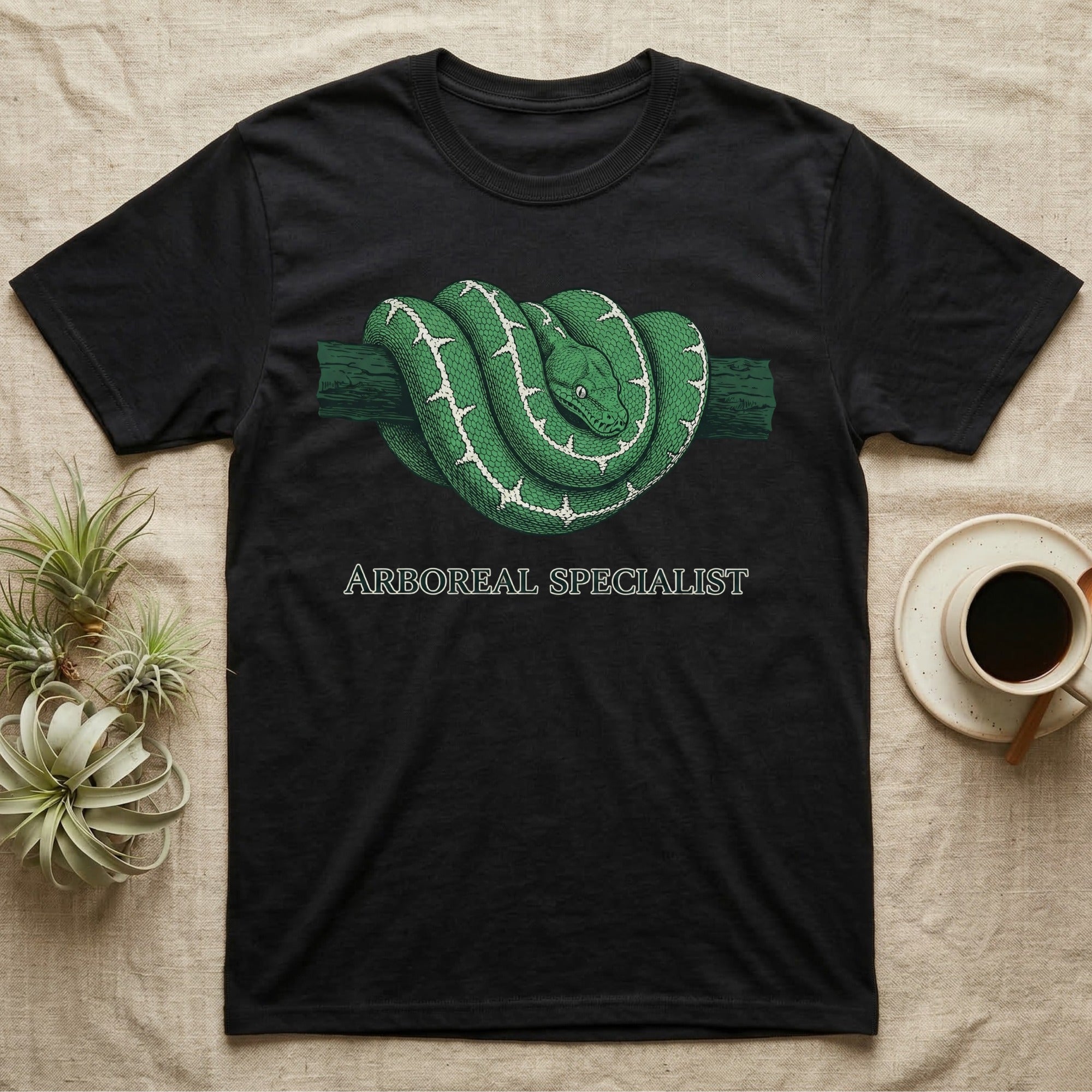 Black t-shirt with green arboreal snake coiled on branch design and text.