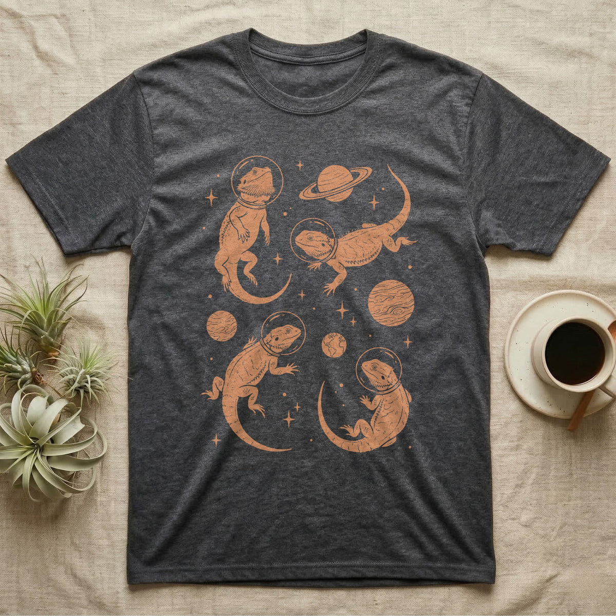 Bearded Dragon Cosmic T-Shirt in Dark Heather — Vintage screen-print illustration of bearded dragons in astronaut helmets floating in space, warm copper monochromatic on dark background.