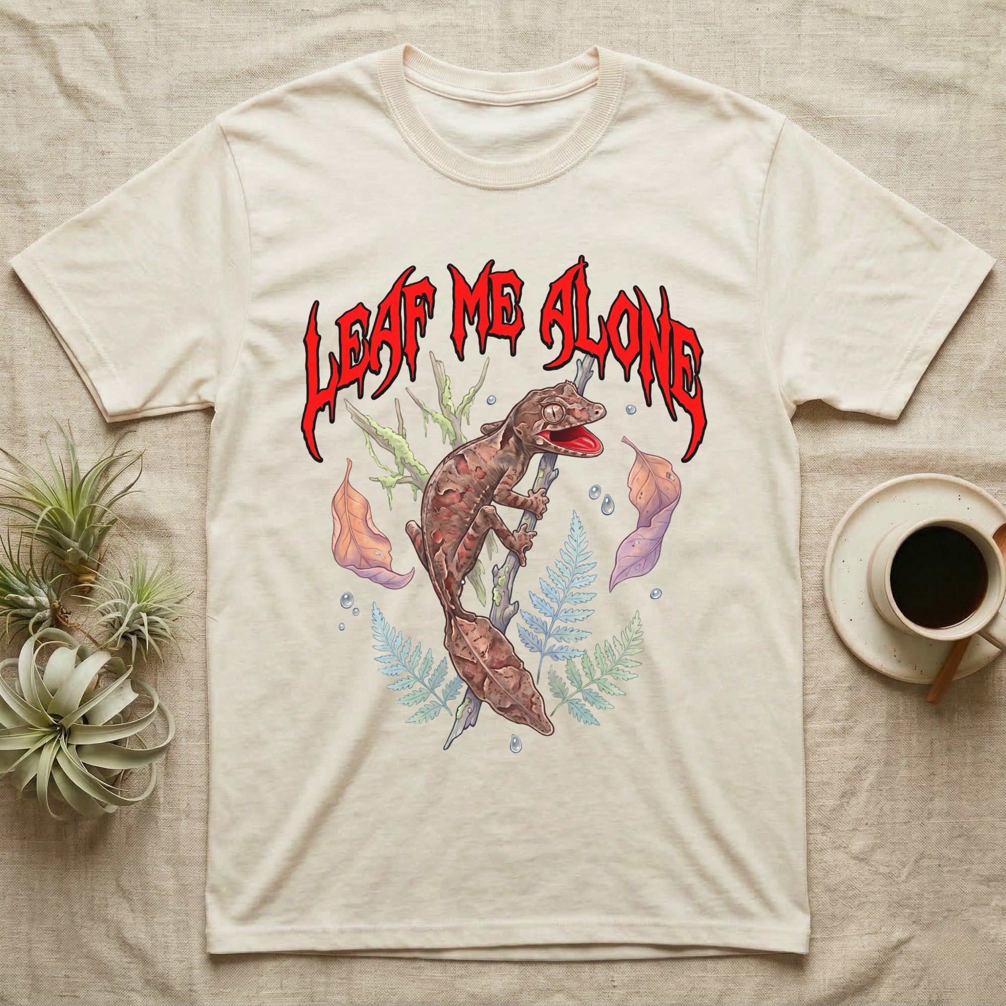 Satanic Leaf-Tailed Gecko Feral T-Shirt in Natural — Satanic leaf-tailed gecko gaping on a twig with dripping blood-red metal "Leaf Me Alone" wordmark above