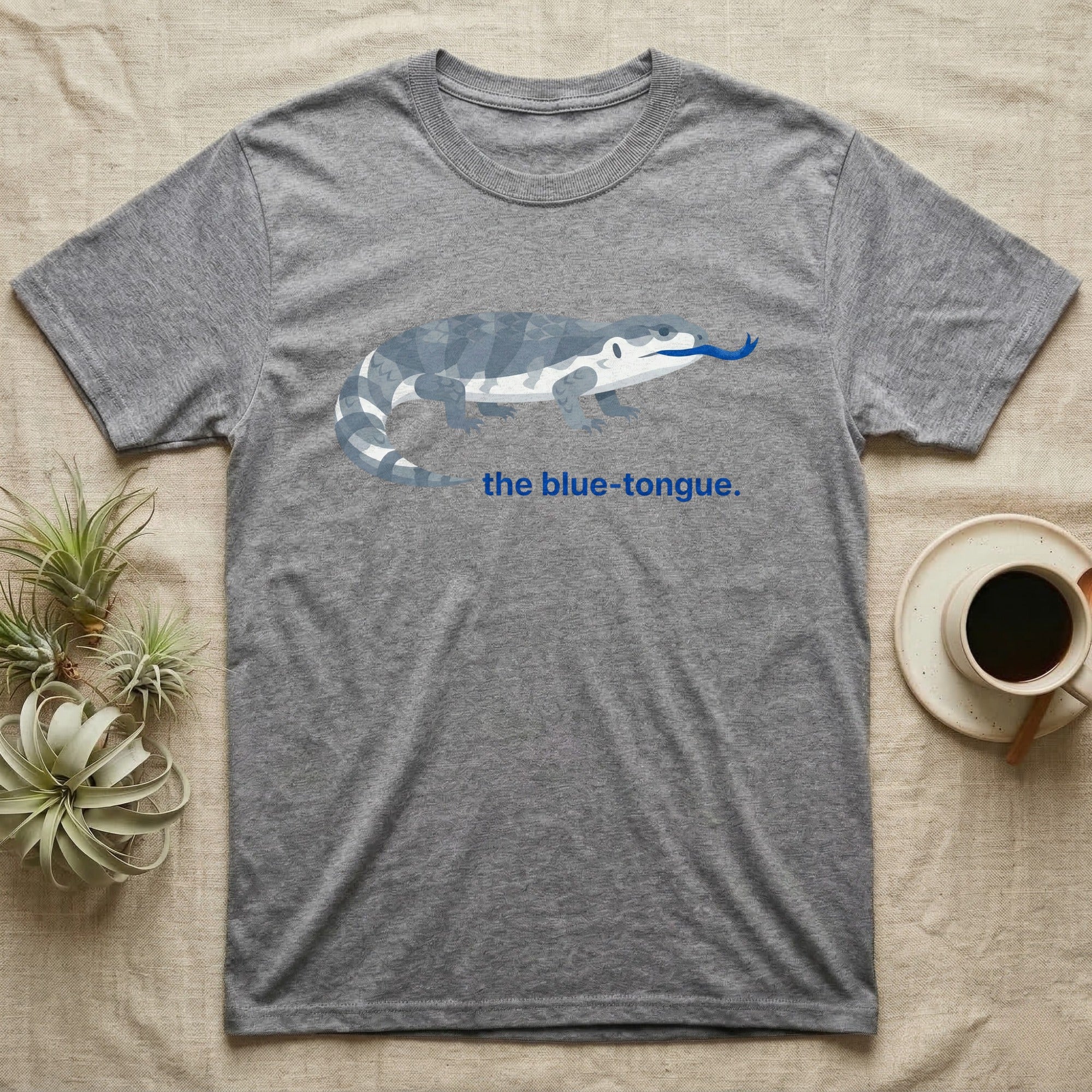 Grey t-shirt with blue-tongued skink graphic and "the blue-tongue." text.