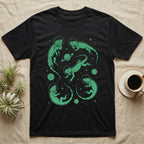 Green Iguana Cosmic T-Shirt in Black — Vintage screen-print illustration of green iguanas in astronaut helmets floating in space, cosmic emerald green monochromatic on dark background.