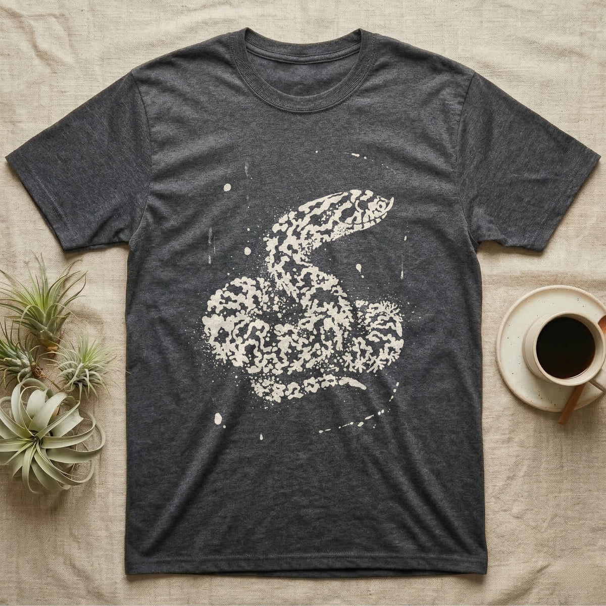 Hognose Bleach Spatter T-Shirt in Dark Heather — A western hognose snake formed from pale bleach spatter on a near-black ground, head turned to show its upturned snout.