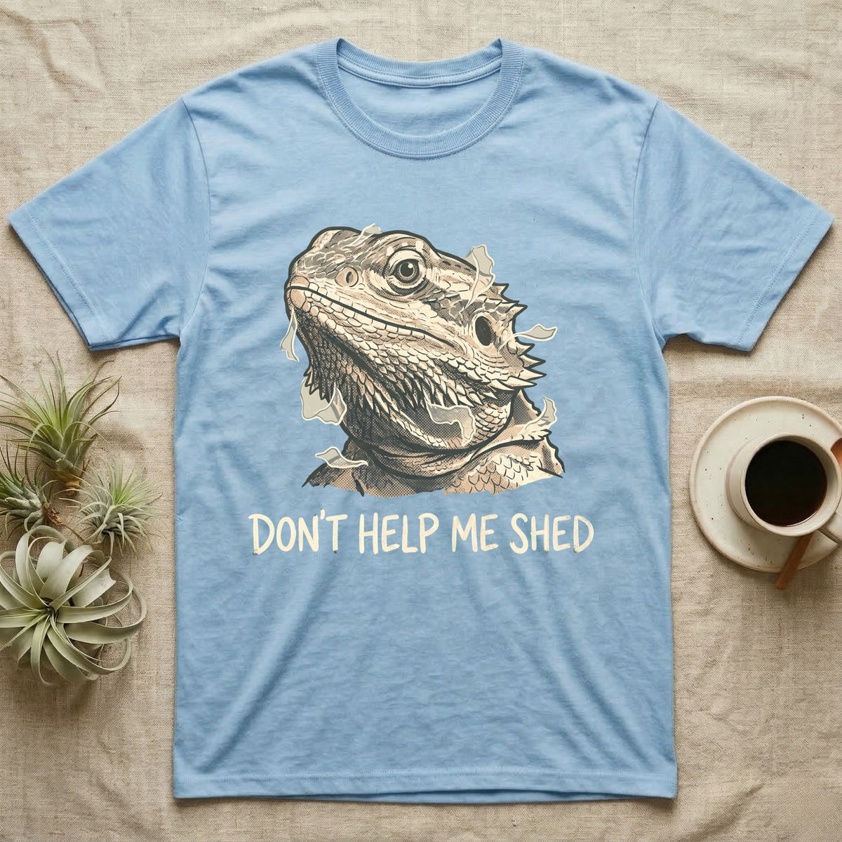 Don't Help Me Shed T-Shirt in Light Blue — Retro-illustration of a bearded dragon mid-shed with a deadpan side-eye and a marker caption reading Don't Help Me Shed.