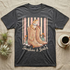 Dark t-shirt with boots, lizard, flowers, and "Sunshine & Scales" text.