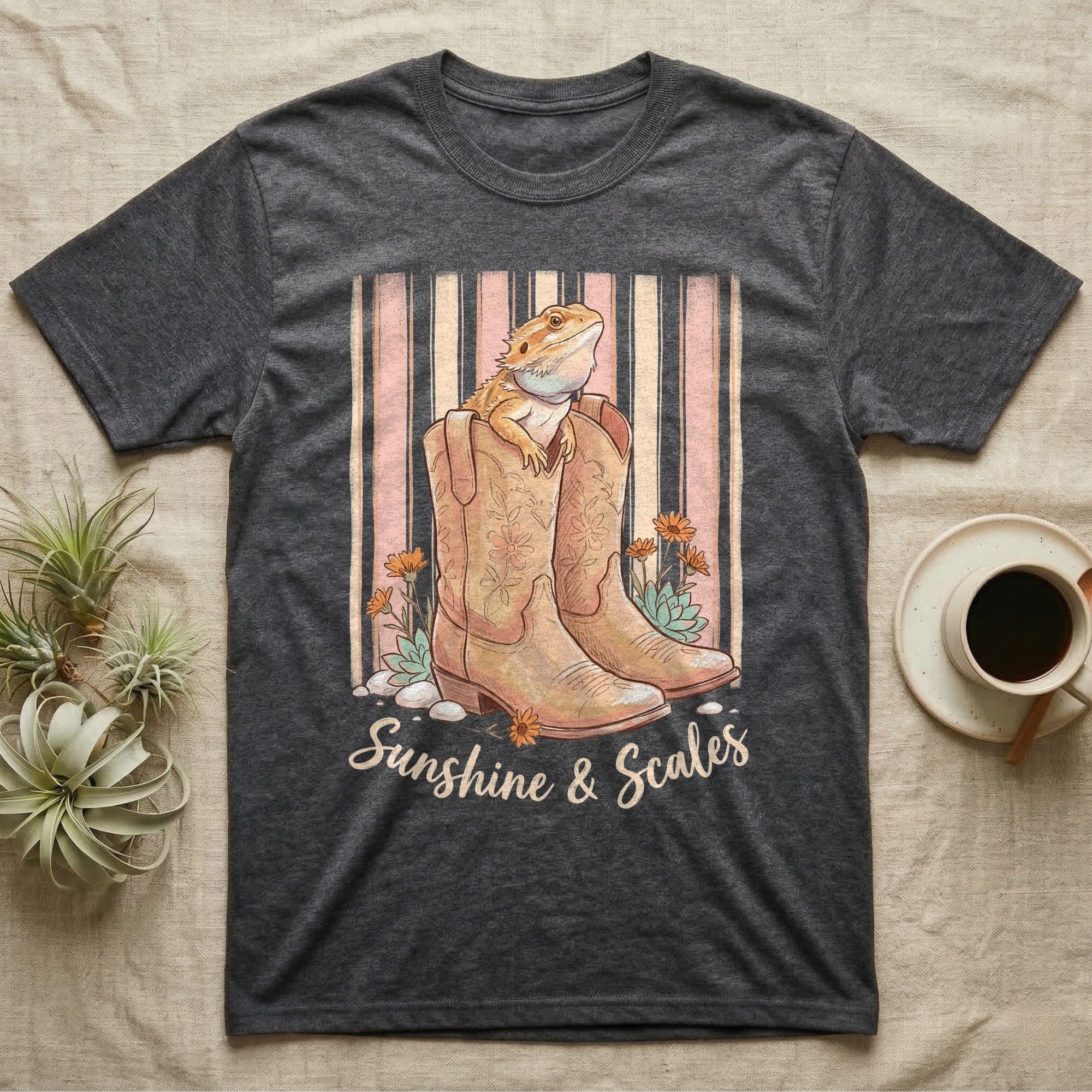 Dark t-shirt with boots, lizard, flowers, and "Sunshine & Scales" text.