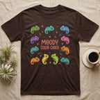 Chameleon Moody T-Shirt in Dark Chocolate — Ten cartoon chameleons in different colours and moods around the coral-pink words MOODY COLOR-CODED