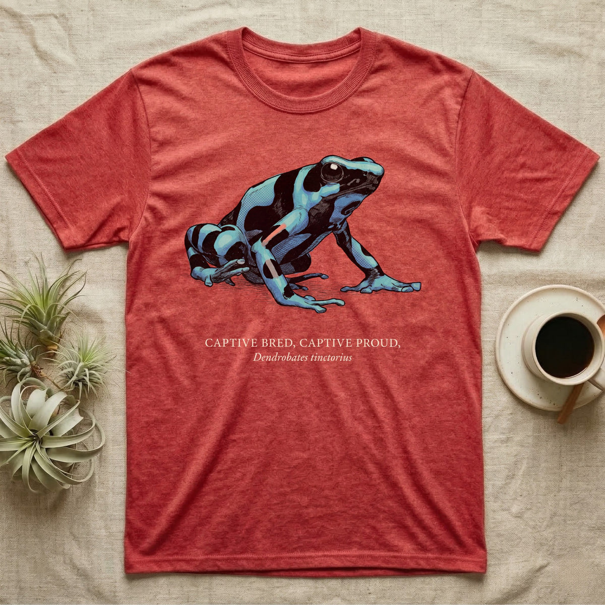 Captive Bred Frog T-Shirt in Heather Red — Naturalist-plate illustration of a healthy dyeing dart frog above a serif creed reading Captive Bred Captive Proud.