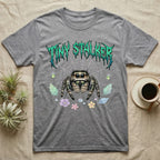 Regal Jumping Spider Feral T-Shirt in Sport Grey — Fuzzy jumping spider with huge eyes in a pastel garden under a spiky iridescent-teal metal wordmark reading TINY STALKER.