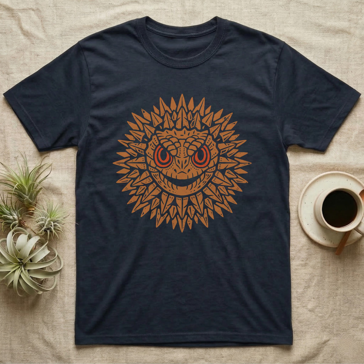 Crocodile Skink Tiny Dragon T-Shirt in Navy — Frontal red-eyed crocodile skink head with dorsal spines flared into an ochre sunburst medallion, red eye ring.