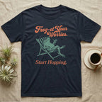 Cane Toad Sun Lounger T-Shirt in Navy — Illustrated cane toad reclining in a beach chair with sunglasses and a cocktail, coral script reading Frog-et Your Worries Start Hopping.