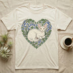Cream t-shirt with a heart-shaped floral design featuring a white curly-haired cat.