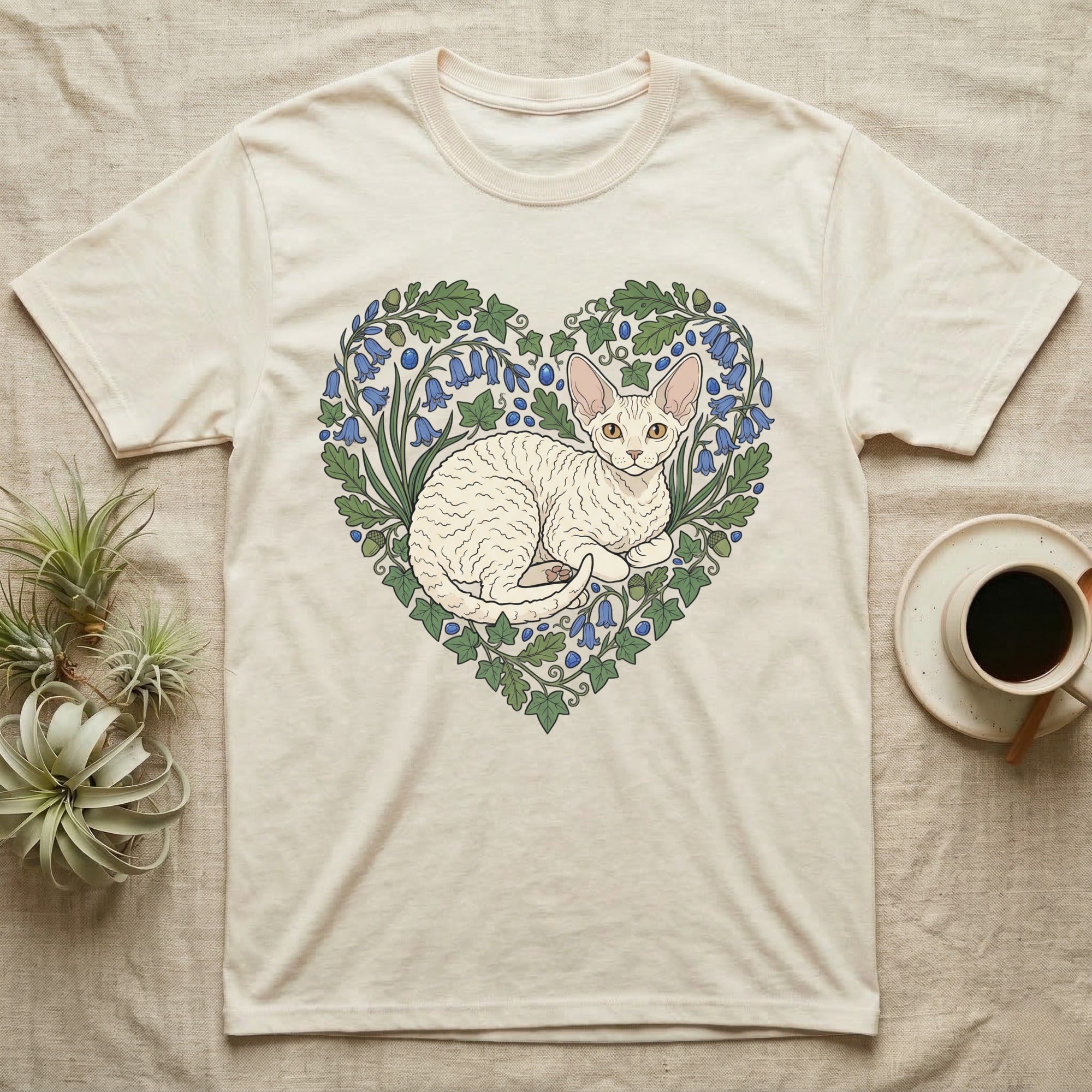 Cream t-shirt with a heart-shaped floral design featuring a white curly-haired cat.