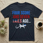 Gecko Four Score T-Shirt in Navy — Block text Four Score and Seven Tails Ago with a flag-filled word above a white gecko silhouette shedding its tail.