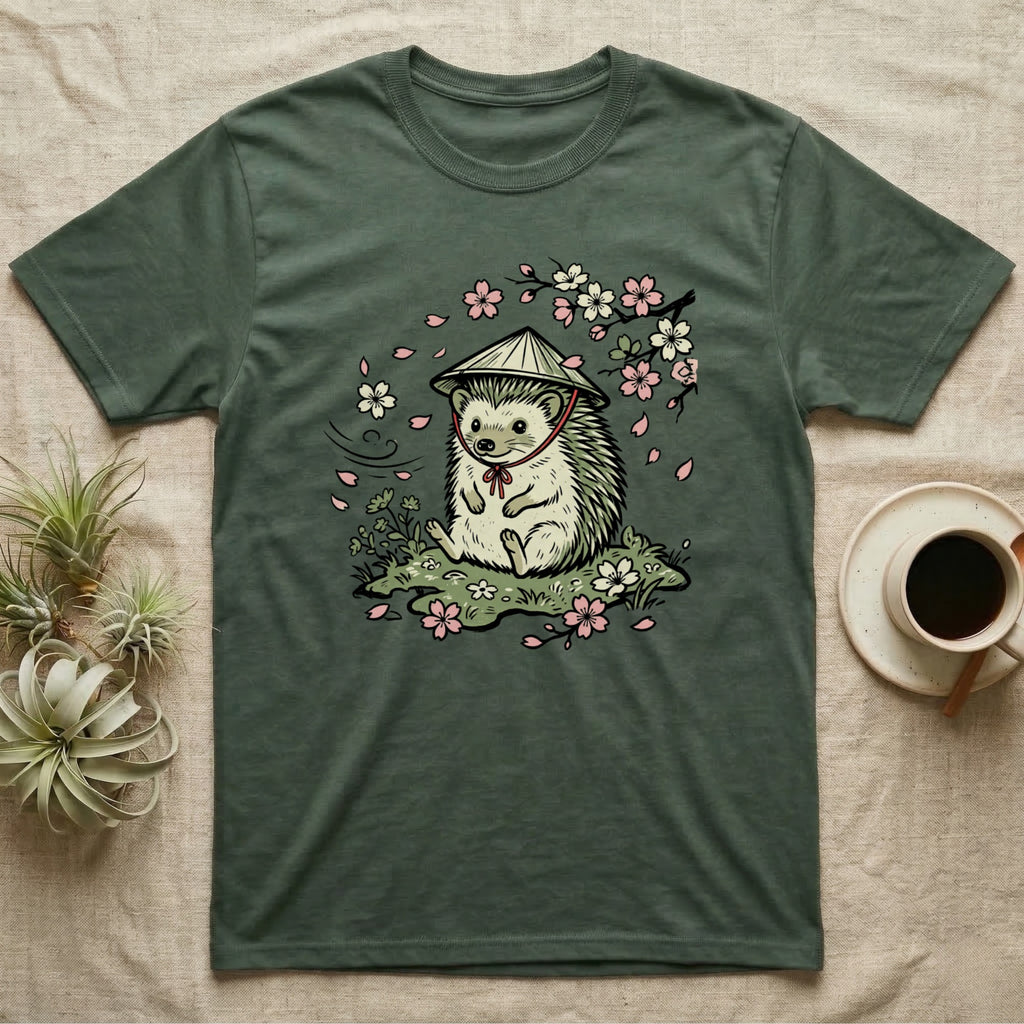 Green t-shirt with cartoon hedgehog wearing a straw hat, surrounded by cherry blossoms.