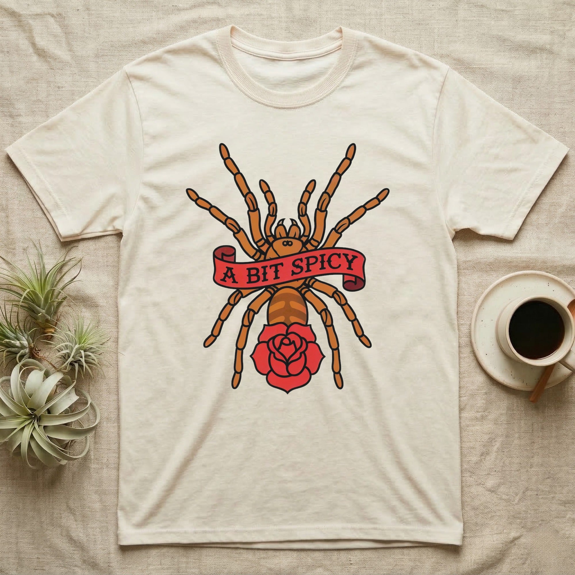 Tarantula A Bit Spicy T-Shirt in Natural — Tattoo-flash orange-baboon-tarantula in threat-pose with banner-scroll "A Bit Spicy" and a flash rose beneath.