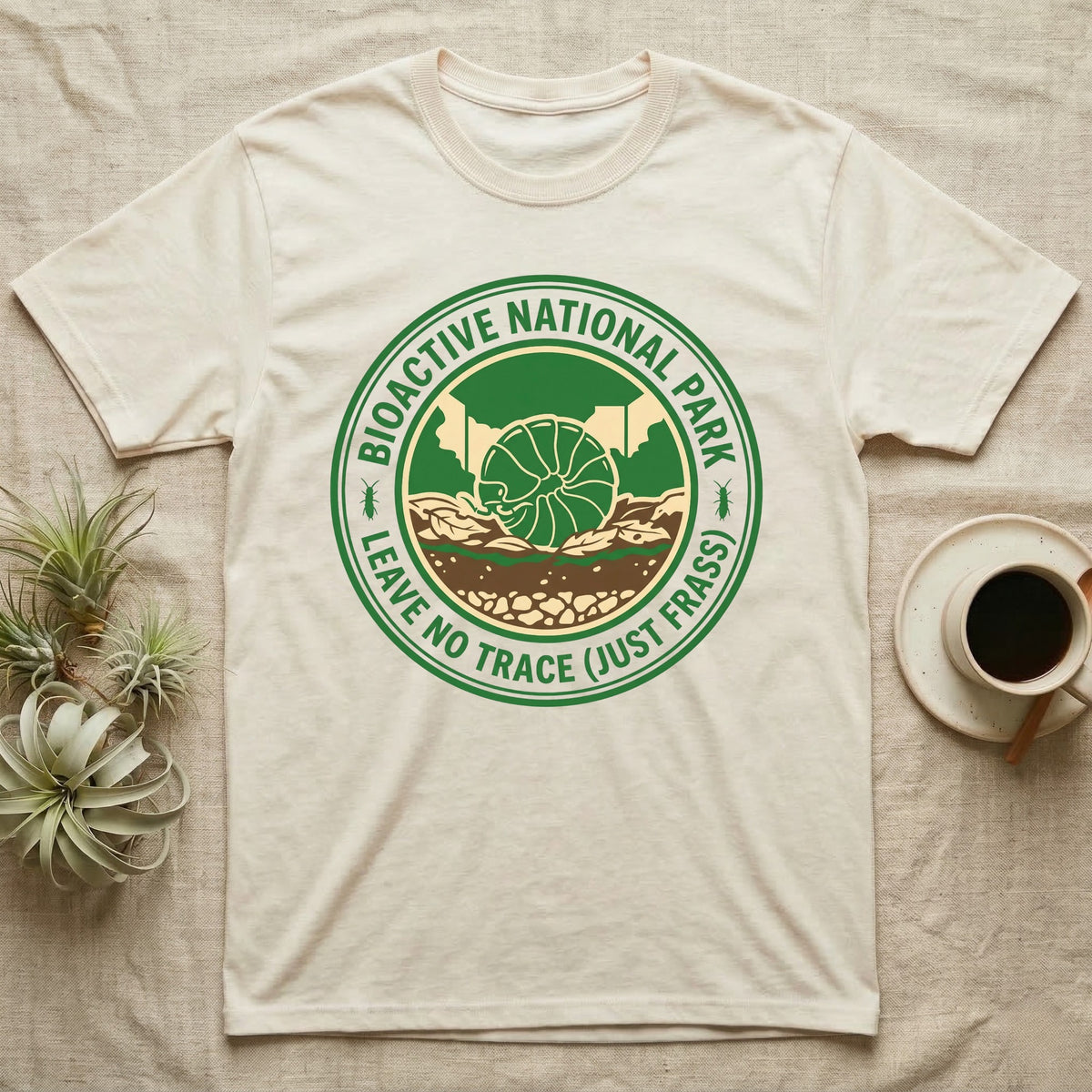 Pillbug Bioactive National Park T-Shirt in Natural — Green ranger badge with a rolled pillbug in a cross-sectioned bioactive enclosure and springtail stars.