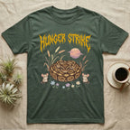 Ball Python Feral T-Shirt in Military Green — Ball python coiled in a loaf in a pastel savanna scene under a spiky honey-gold metal wordmark reading HUNGER STRIKE.