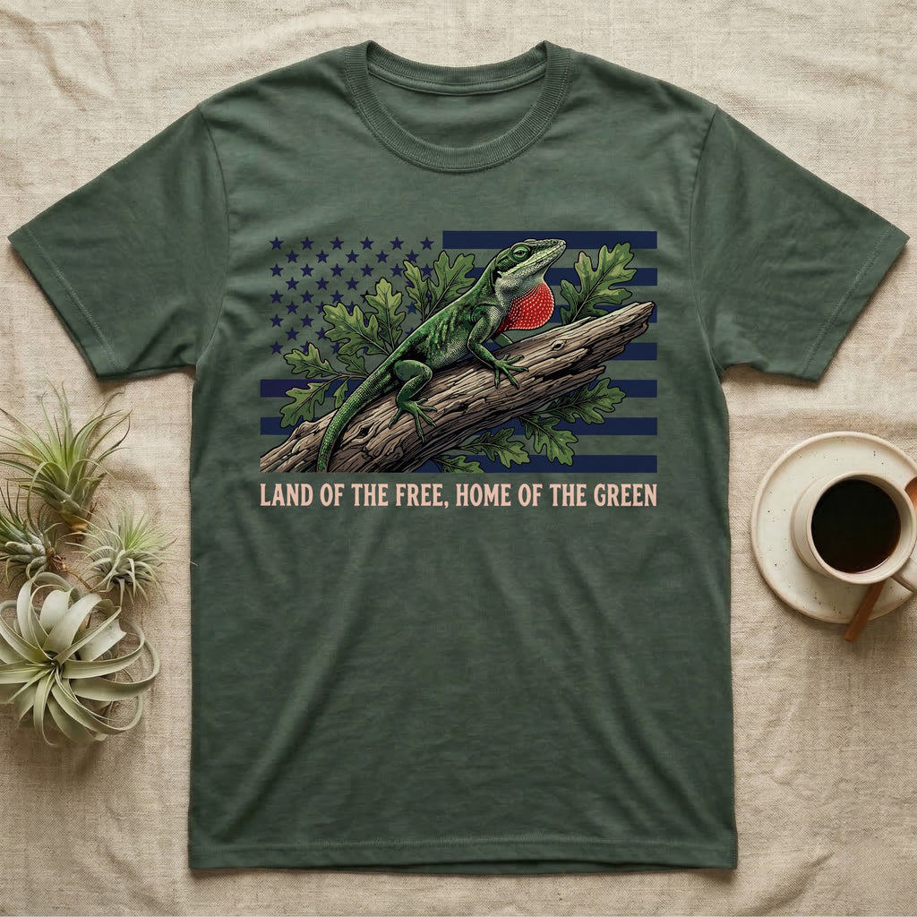 Green Anole 1776 T-Shirt in Military Green — Realistic green anole with a red dewlap on a branch over a distressed flag under text Land of the Free, Home of the Green.