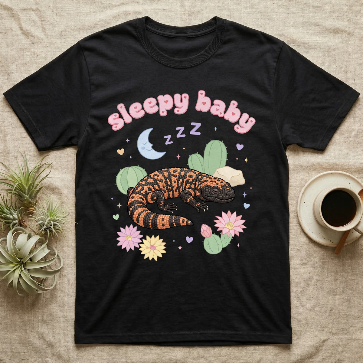 Gila Monster Baby T-Shirt in Black — Pastel Gila monster with sleepy eyes, crescent moon and Z Z Z, puffy salmon bubble wordmark "sleepy baby" above.