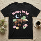 Gila Monster Baby T-Shirt in Black — Pastel Gila monster with sleepy eyes, crescent moon and Z Z Z, puffy salmon bubble wordmark "sleepy baby" above.
