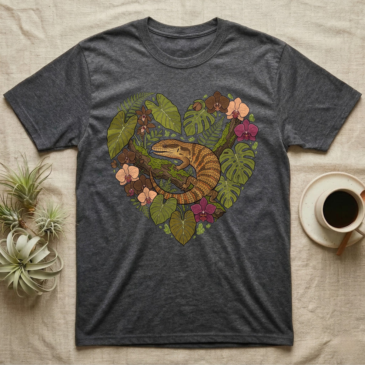 Dark t-shirt with heart-shaped botanical design featuring a lizard.
