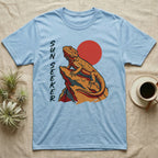 Light blue t-shirt with a bearded dragon on a rock and a red sun graphic.