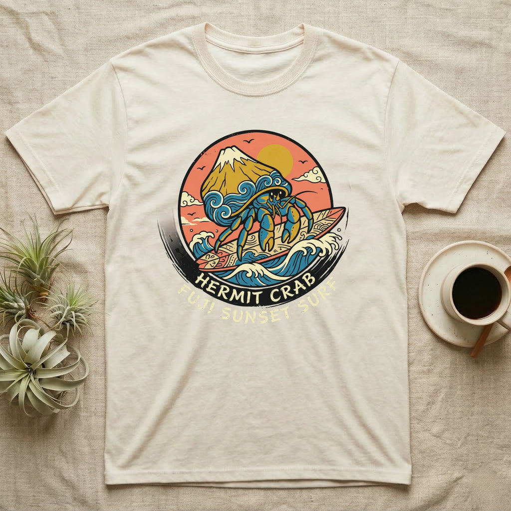 Cream t-shirt with a hermit crab surfing at sunset graphic.