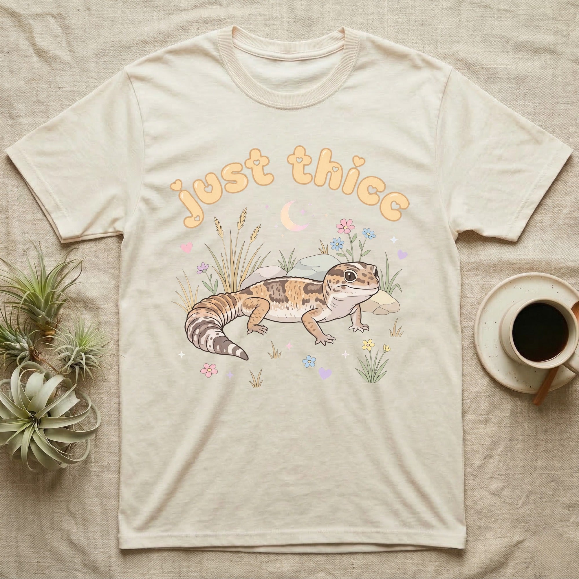 African Fat-Tailed Gecko Softie T-Shirt in Natural — African fat-tailed gecko with a plump tail under a puffy pastel "just thicc" bubble wordmark with tiny hearts.
