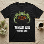 Deadpan mugshot of an olive-green fire-bellied toad on black, captioned I'm mildly toxic, wash your hands. — shown on a Black tee.