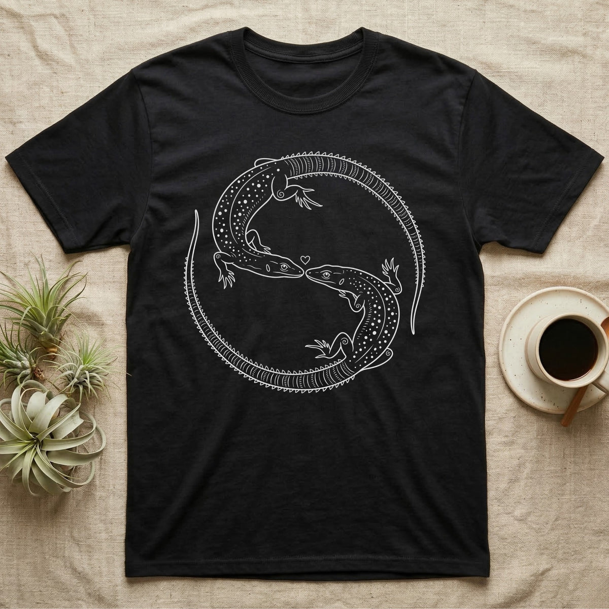 Ackie Monitor Roundel T-Shirt in Black — Two ackie monitors in fine white line art, mirrored at 180 degrees around a tiny heart, tails sweeping outward.