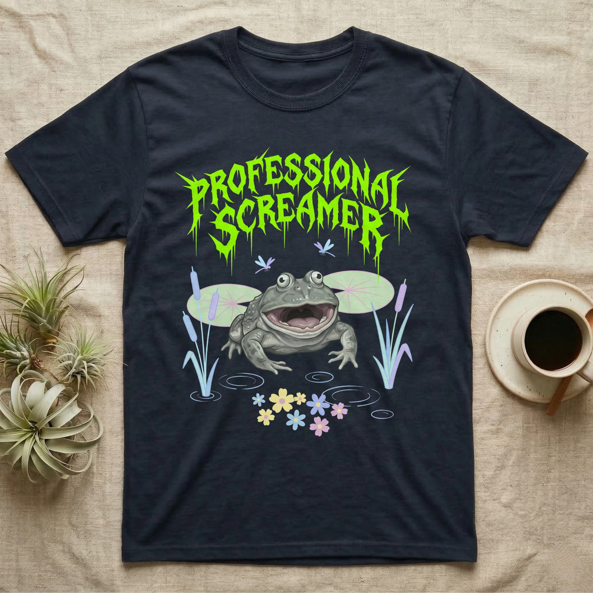 Budgett's Frog Feral T-Shirt in Navy — Budgett's frog with wide screaming mouth under jagged acid-green metal text PROFESSIONAL SCREAMER with lily pads