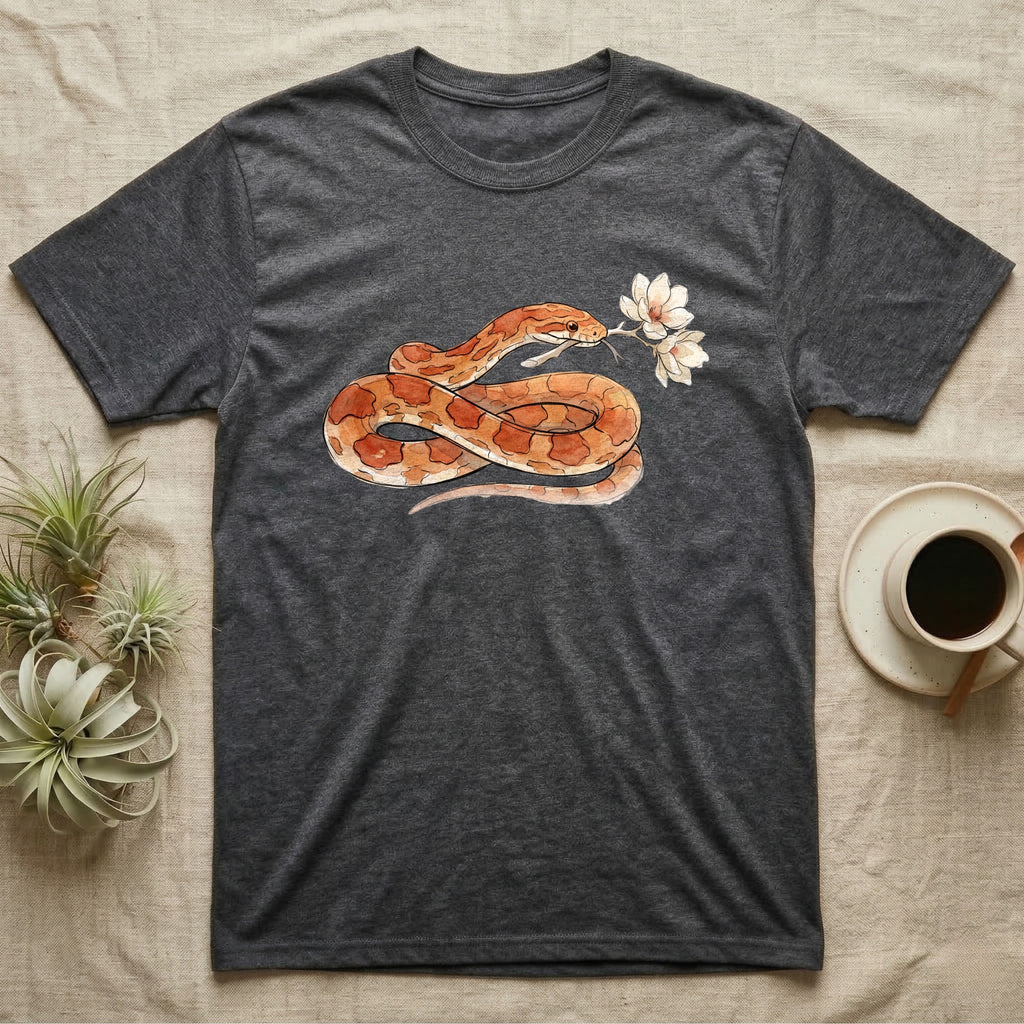 Corn Snake Blossom T-Shirt in Dark Heather — Watercolor illustration of an orange-and-cream corn snake holding a magnolia blossom sprig, on a dark grey t-shirt.