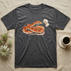 Corn Snake Blossom T-Shirt in Dark Heather — Watercolor illustration of an orange-and-cream corn snake holding a magnolia blossom sprig, on a dark grey t-shirt.