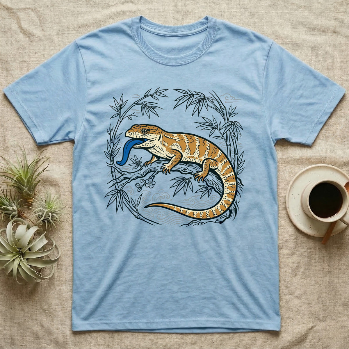 Blue t-shirt with orange lizard and bamboo illustration.